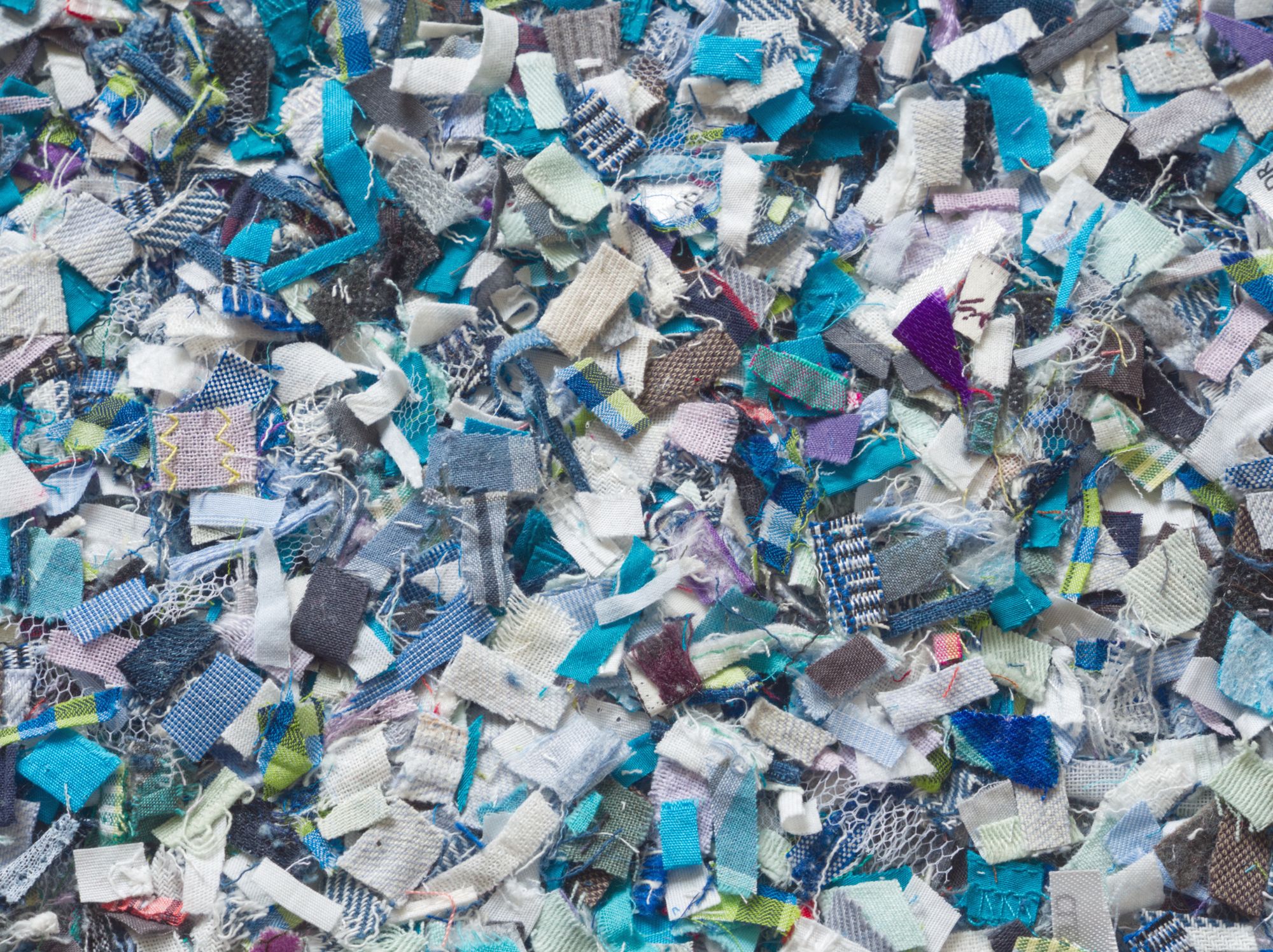 Close view of shredded fabric pieces in blues and whites